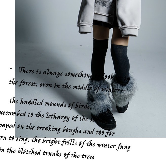the image shows a girl's legs from the knees down, wearing long black socks and gray furtrimmed boots. the background is a simple gray, and the overall aesthetic is monochromatic and muted. superimposed over the image is a poetic text passage describing a winter forest scene, focusing on the quiet stillness of the season and the subtle beauty of nature in winter.  the text is stylized and adds a literary quality to the fashion image.
