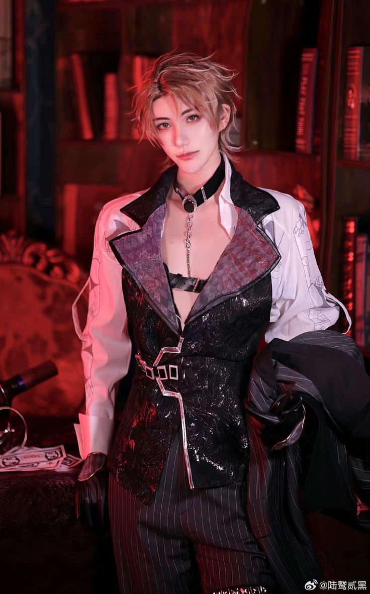 a person in costume, likely a cosplay, poses for a photograph. the individual is wearing a black choker, a black harness under a black vest with unusual geometric detailing, a white buttondown shirt with dark accents on the collar, and pinstripe pants. they also hold a black jacket draped over their arm. the individual has blonde hair styled in a tousled manner. the backdrop is a bookshelf filled with books, suggesting an indoor setting. prop money is scattered on a surface near the bottom of the frame.