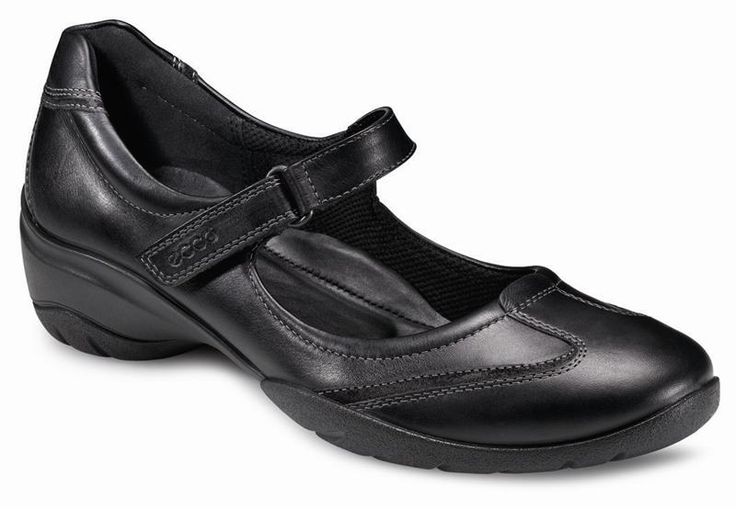 a black leather ecco mary jane shoe is displayed against a white background. the shoe has a strap over the instep and a low wedge heel.