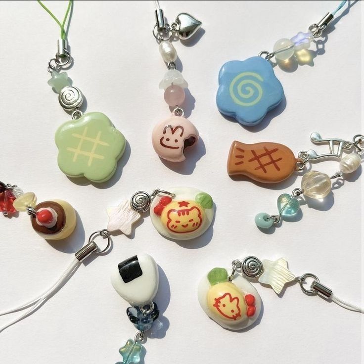 a collection of handmade phone charms or keychains featuring cute cartoon characters and food themes in pastel colors. the charms are made with beads and various shaped pendants, showcasing a japaneseinspired style.