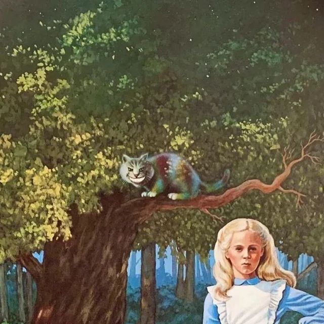 this image is from the book "alice in wonderland" by lewis carroll. it shows alice standing in a forest next to a large tree. the cheshire cat is perched on a branch of the tree, looking at alice with its signature mischievous grin.  the scene is whimsical and surreal, capturing the essence of carroll's classic tale.