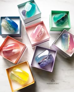 an arrangement of various handmade soap bars with beautiful colours and different shapes, some are clear and others are opaque. all of them look colorful and inviting for a luxurious and aromatic bath experience.