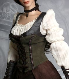 a woman models a dark green corset with a brown leather trim and a white, puffysleeved blouse. the corset laces up the front and is adorned with metal accents. she also wears dark brown gloves and a long brown skirt. the image focuses on the details of the bodice and the materials used.
