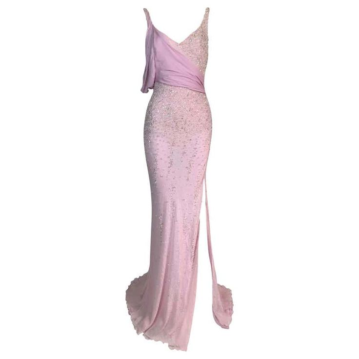 a fulllength view of a pink formal evening gown. the dress is decorated with sequins and has an asymmetrical neckline, one strap, and chiffon trim. the dress has a slit in the skirt. the background is plain white.
