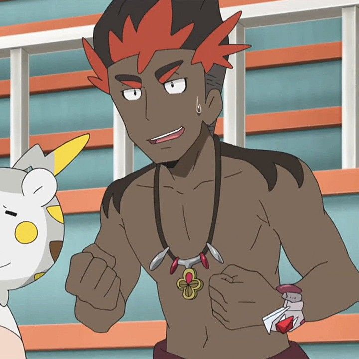 a cartoon male character is shown in the image. the male has dark skin and red hair with orange tips. he has a small, black, stud earring on his left ear. he's shirtless, wearing a dark brown necklace with a gold pendant in the shape of a 4leaf clover with red jewels around the clover. on his right wrist, he wears a white bracelet with a red gem attached.  the male has a muscular build with arms flexed, and he's smiling while looking toward the right. he has a confident look on his face.  in the background is a building with orange and blue stripes. on the left side of the image is a partially visible white, cartoon animal with a yellow spot on its chest and yellow tail.  the background appears to be the outside of a building, possibly a gym or a practice area.