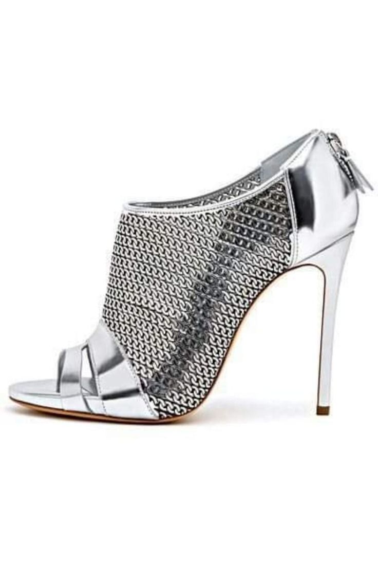 the image shows a single, silver highheeled shoe.  the shoe features a peeptoe design and is made of a combination of metallic leather and a silver chainmaillike mesh fabric that covers a large portion of the shoe's upper. the heel is a slender stiletto. the shoe has a zip closure on the back.  the shoe is positioned at a slight angle, showcasing its profile. the background is plain white, making the shoe the focus.