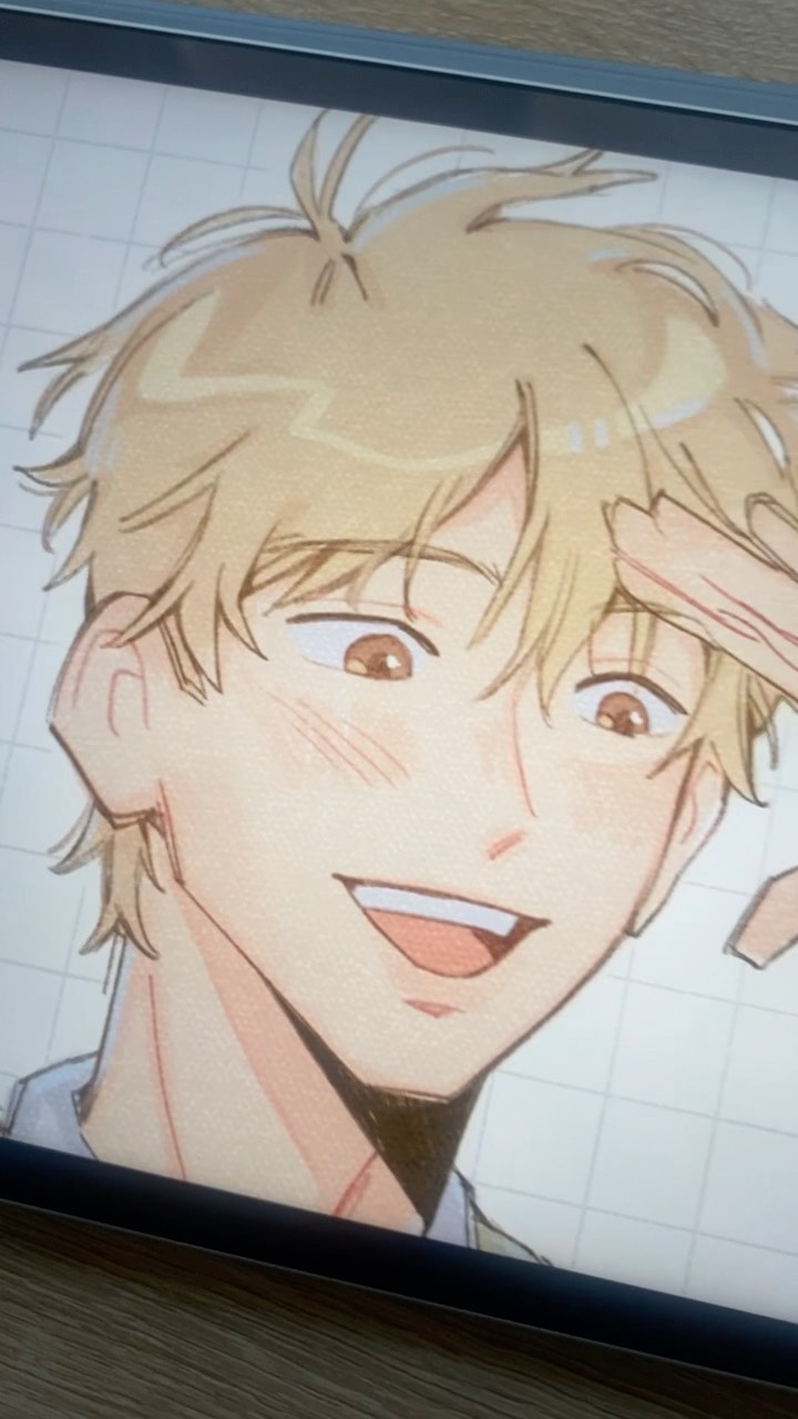 the image shows a closeup digital drawing of an animestyle boy. he has light brown or blond hair, a cheerful expression with blush on his cheeks, and is depicted from the chest up.  the art style is reminiscent of manga or webtoon illustrations, with soft lines and shading.  the image seems to be a workinprogress, possibly displayed on a graphic tablet screen, as a grid is visible in the background.  the overall mood is light and pleasant.