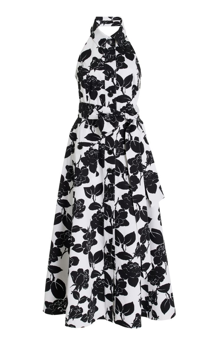 a white and black floral halter dress with a flowy skirt. the dress has a buttonup front and a tie at the waist. it is perfect for a summer party or a casual occasion.