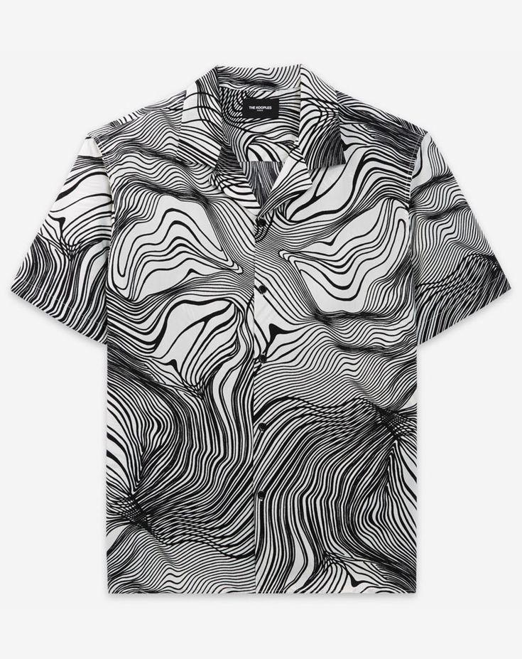 a shortsleeved buttondown shirt with a black and white graphic pattern is centered against a white background. the pattern features swirling and wavy lines resembling topographical contours. the shirt has a classic collar, and the top buttons are visible. the label "the kooples" is subtly visible on the inside collar. the shirt appears to be new or recently ironed, lacking wrinkles or signs of wear.