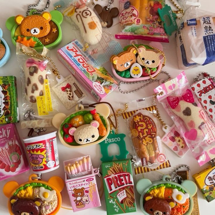 the image shows a collection of japanese foodthemed keychains and trinkets, including candy, snacks, bread, and desserts. there are rilakkuma themed items as well as crackers, biscuits, lunch boxes, and chocolates.