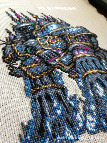 a closeup shot of a crossstitched image of howl's moving castle. the intricate details and vibrant colors of the castle are beautifully captured in the needlework. the castle appears to be floating in the air, surrounded by clouds and other elements that create a sense of wonder and magic.