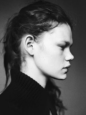 a black and white portrait of a woman in profile. she is wearing a sweater and has her hair pulled back.