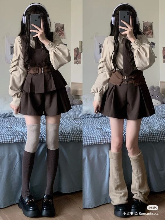 a girl with black hair is posing for a fashion shoot. she is wearing a white shirt with brown suspenders and a brown skirt. she is also wearing black boots and knee high socks. she is sitting on a bed with a checkered blanket.  she is holding a phone in her hand and her white headphones are around her neck. she is looking at the phone with a confident expression.  she looks very fashionable and trendy.