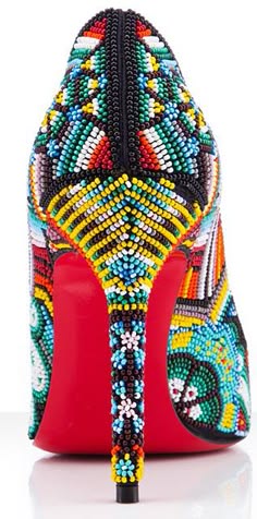 a close up of a red high heel shoe with colorful beading, the shoe is ornately designed and appears to be a designer shoe. the beading is very detailed and creates a mosaiclike pattern on the shoe.