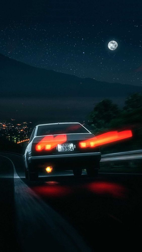 a white car is speeding down a mountain road at night, with its taillights leaving a red streak. the moon is shining brightly in the sky, and the city lights can be seen in the distance.