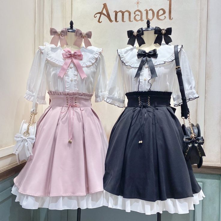the image shows two mannequins dressed in amavel lolita fashion outfits. both outfits feature a white blouse with a peter pan collar, lace trim, and a bow at the center. one outfit has a pink skirt and the other has a black skirt. the skirts are highwaisted with a laceup back and a tiered ruffle hemline. the mannequins are accessorized with bows in their hair and small handbags.