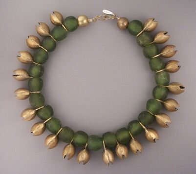 a necklace made of green round beads strung together with gold tulip shaped charms hanging from each bead. the necklace is finished with gold round beads and a gold chain with a clasp.