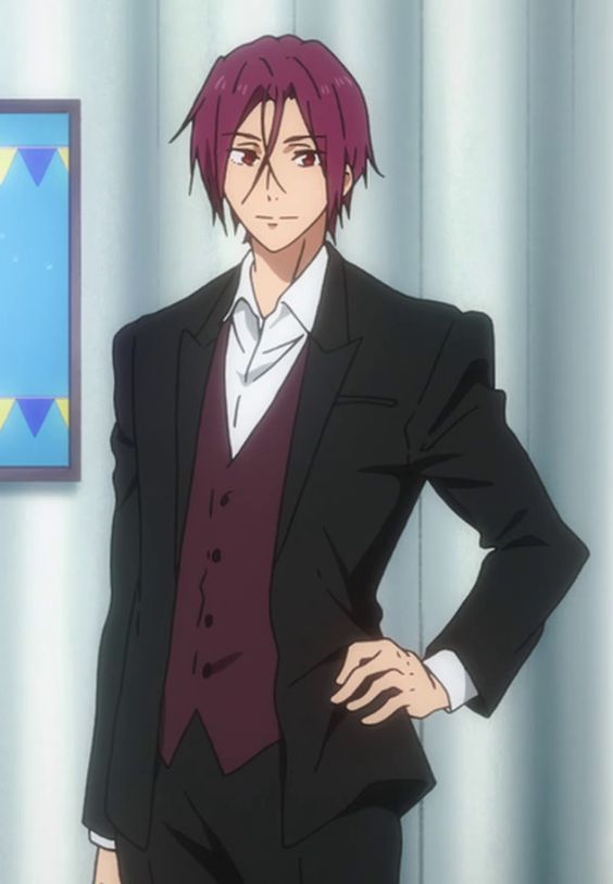 the image shows an animestyle male character wearing a black suit with a maroon vest and a white shirt underneath. he is standing with his hand on his hip and has a confident expression on his face. the background is a simple white wall with a blue and white geometric pattern on the left side. the image appears to be a still from an anime series or movie.
