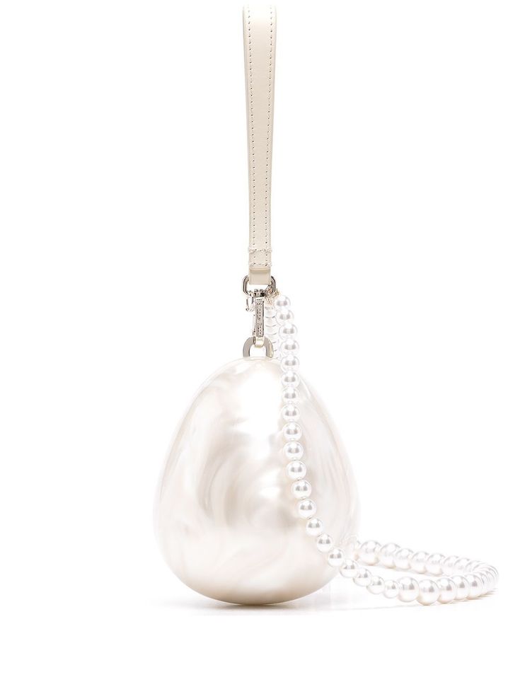 a white eggshaped handbag is shown hanging from a white strap. the bag is embellished with a pearl string handle.