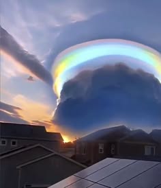 a stunning sunset with a beautiful iridescent cloud formation.  the clouds are illuminated by the setting sun, creating a vibrant rainbow of colors. the clouds appear to be swirling and moving, adding to the ethereal beauty of the scene. the scene is captured from a low angle, allowing the viewer to appreciate the full extent of the cloud formation.