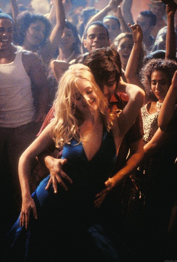 a woman in a blue dress is dancing with a man in