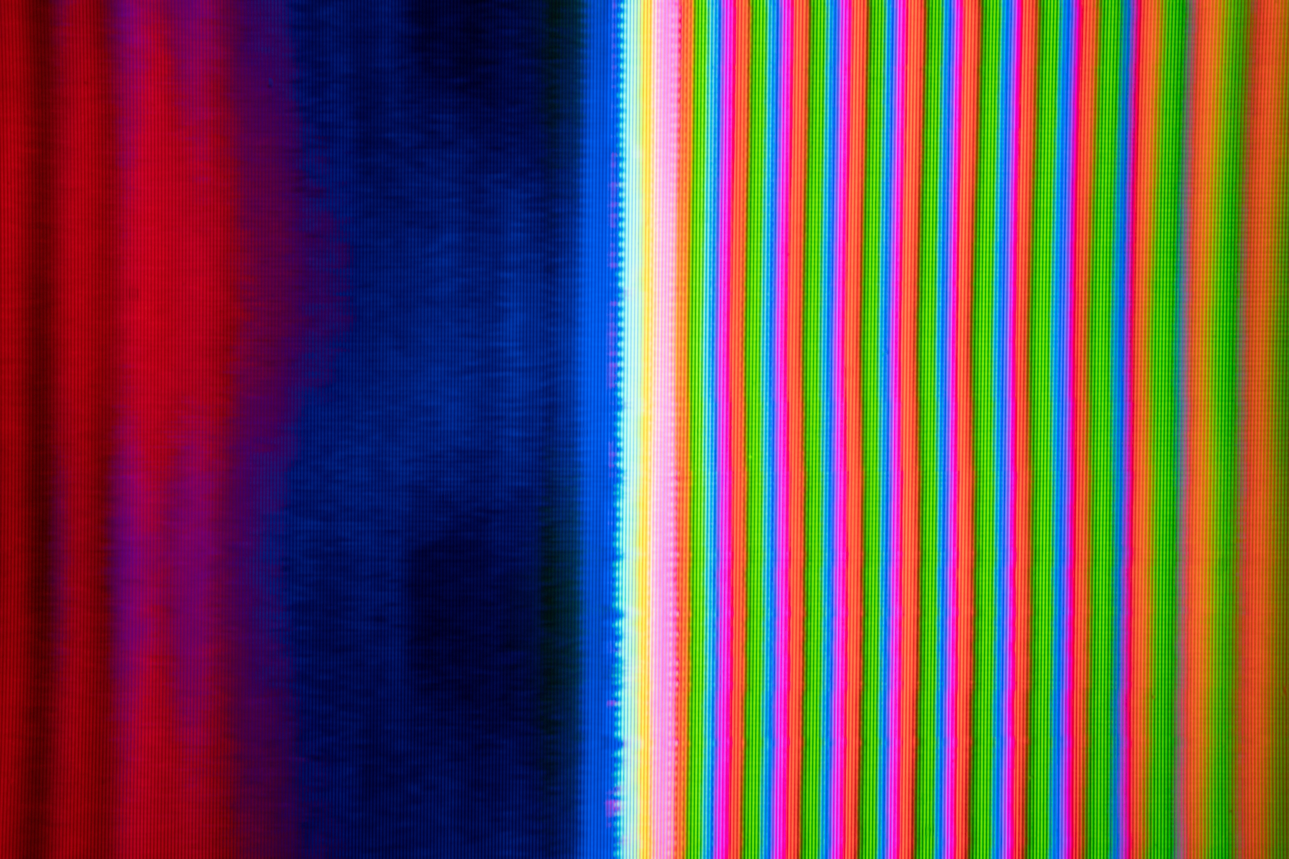 an abstract image of colorful vertical bars and lines, resembling a distorted television screen displaying static noise. the colors are bright and vibrant, creating a visually striking pattern.