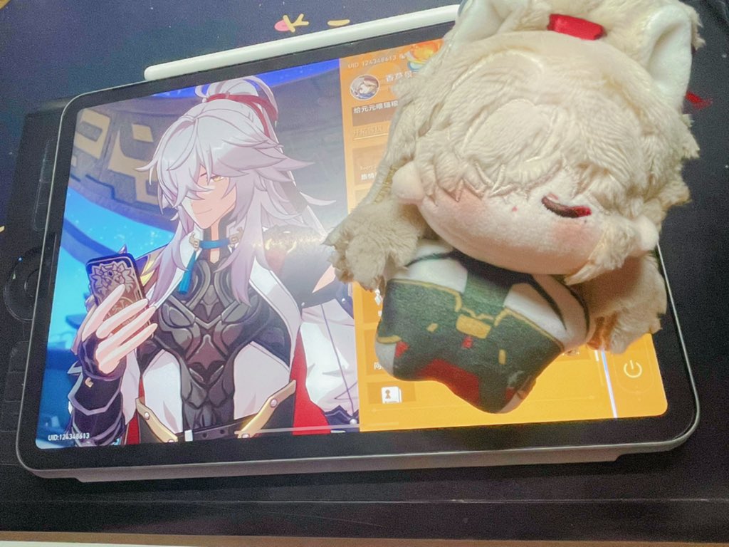 an image of a cute plush toy of the genshin impact character albedo lying on a tablet screen. the screen displays a digital illustration of albedo from the game. the plush toy is soft and fluffy, with white hair and a cute expression on its face. the image is full of color and detail, and the plush toy is a great representation of the character.