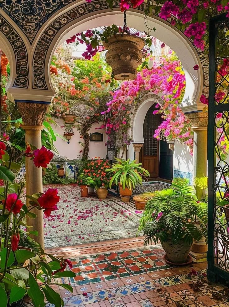 a vibrant and inviting courtyard garden showcases moorish architecture with ornate archways adorned with colorful bougainvillea. potted plants of various sizes and types are scattered throughout the space, adding to the lush atmosphere. the tile flooring features intricate patterns and designs, contributing to the overall aesthetic. light streams through the garden, highlighting the details of the architecture and plants. a hanging planter adds an additional touch of greenery to the space. a wrought iron gate is visible on the right, creating a sense of enclosure and security. the scene is a harmonious blend of nature and design, creating a beautiful and serene outdoor space.