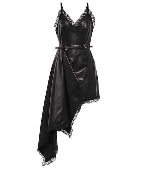 a black, belted leather dress with lace trim and spaghetti straps on a white background. the dress has an asymmetrical skirt that is long on one side.