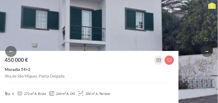 a white house with green shutters is for sale. the price is 450,000 €. the house has a balcony with a view of the garden and trees. the house is located in ponta delgada, azores, portugal.