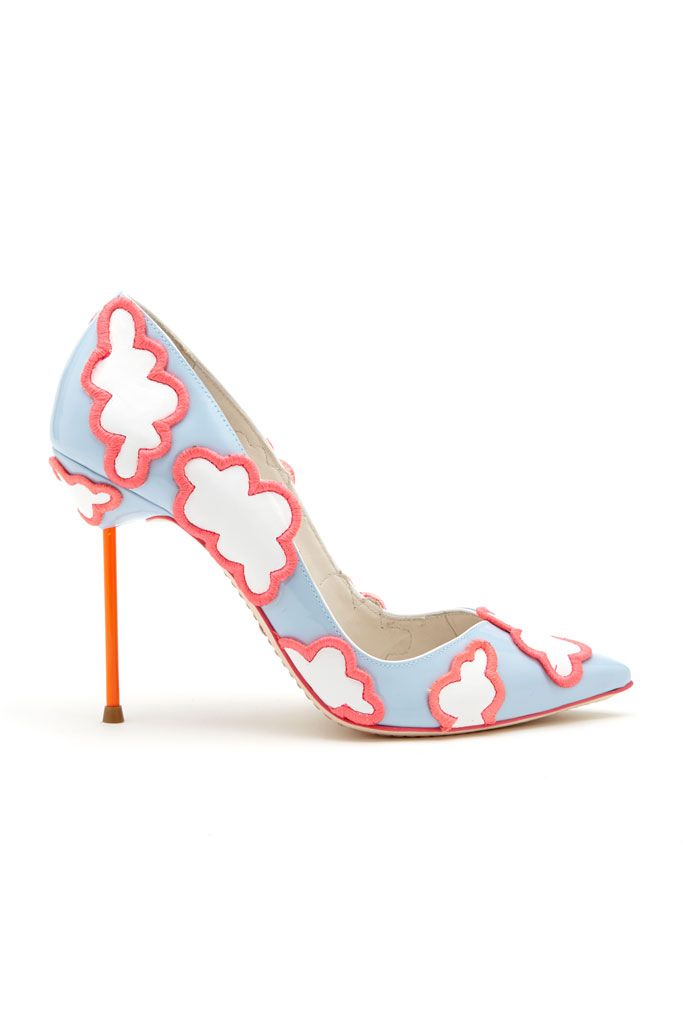 a single light blue high heel shoe is set against a plain white background. the shoe is adorned with a cloud pattern, outlined with pink trim. it features a pointy toe and an orange stiletto heel. the shoe is positioned to show its side profile.