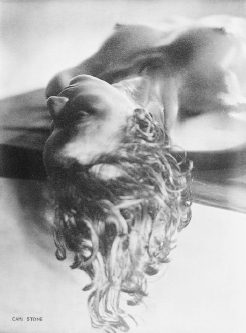 the image is a black and white photograph by carl stone depicting a nude female figure reclining.  the woman's body is partially blurred, giving a dreamlike or ethereal quality. her hair is wet and appears to be cascading around her head and shoulders.  the focus is soft, drawing attention to the form and texture of the body rather than sharp detail. the overall mood is sensual and evocative, suggesting a feeling of intimacy and fluidity.  the photographer's signature "carl stone" is visible in the bottom left corner.
