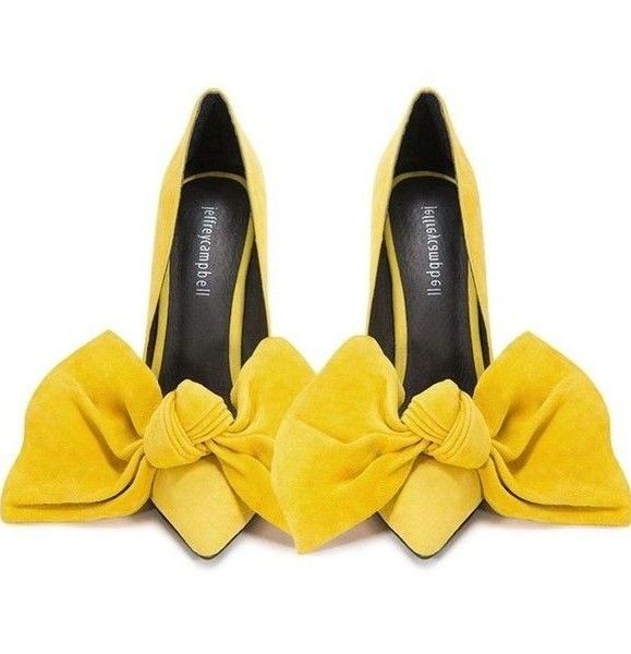 the image shows a pair of yellow jeffrey campbell pumps with oversized bows on the toe. the shoes are made of suede and have black interior linings. the bows are large and fluffy, adding a dramatic touch to the design.