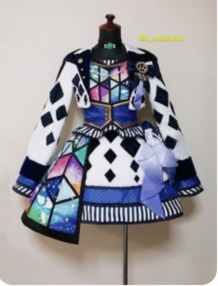 a white and blue dress with galaxy print detailing is shown on a mannequin. the dress is short with puffy sleeves and features diamond and stripe patterns throughout.