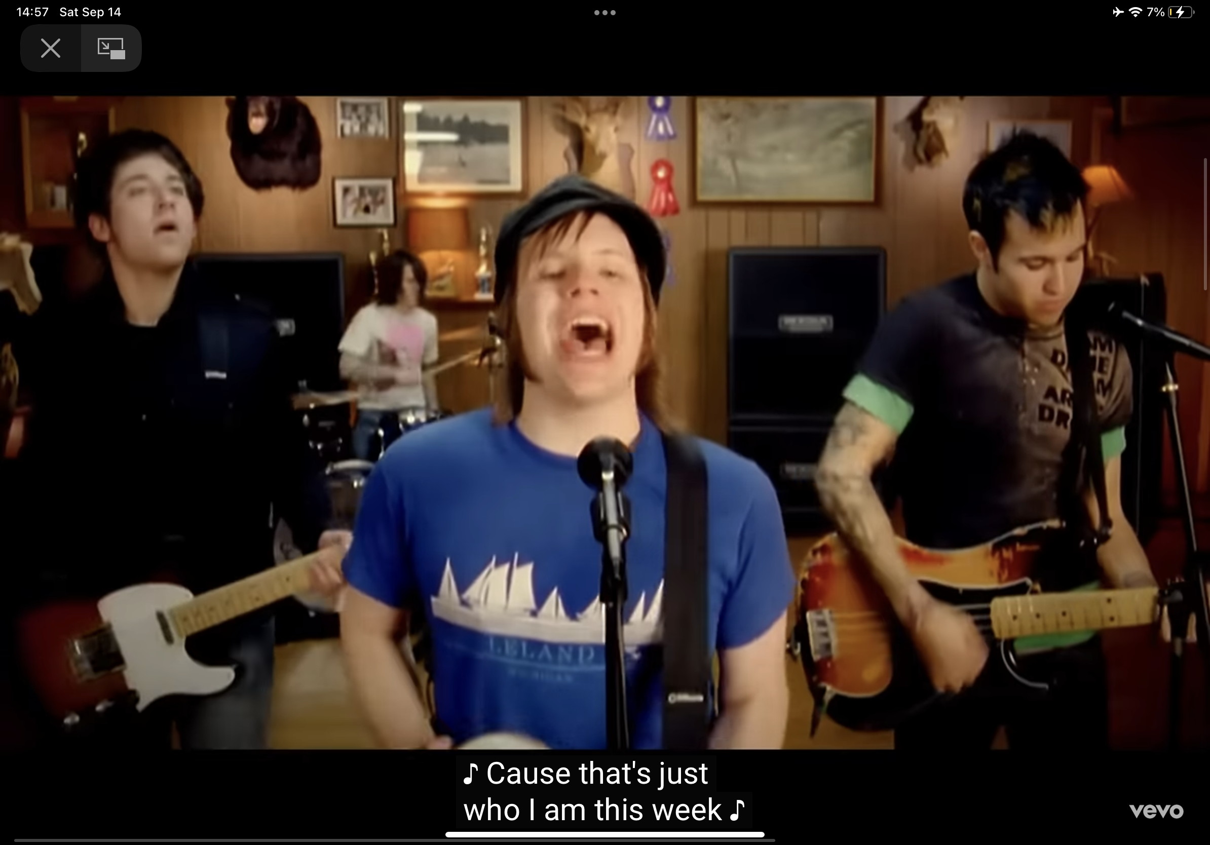 the image shows a fourmember band performing in a room. the lead singer, wearing a blue tshirt, is in the center, passionately singing into the microphone. he is surrounded by his bandmates playing instruments: a guitarist to his left, a bassist to his right, and a drummer in the background. the room is decorated with hunting trophies and pictures on the walls, and musical equipment like amplifiers are visible. the image has a warm color palette and seems to be a still from a music video, as indicated by the "vevo" logo in the bottom right corner.