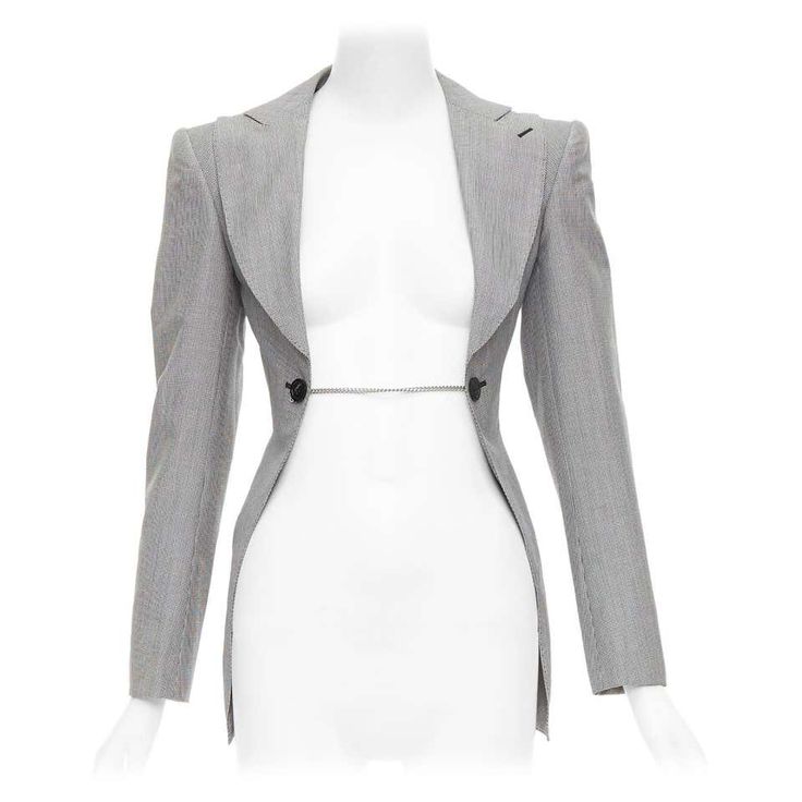 a women's gray long blazer with a chain detail, a fitted and tailored style. it is a modern and elegant piece of clothing that can be worn for professional occasions or business meetings. the blazer is made of highquality fabric and has a slim fit that accentuates the figure.