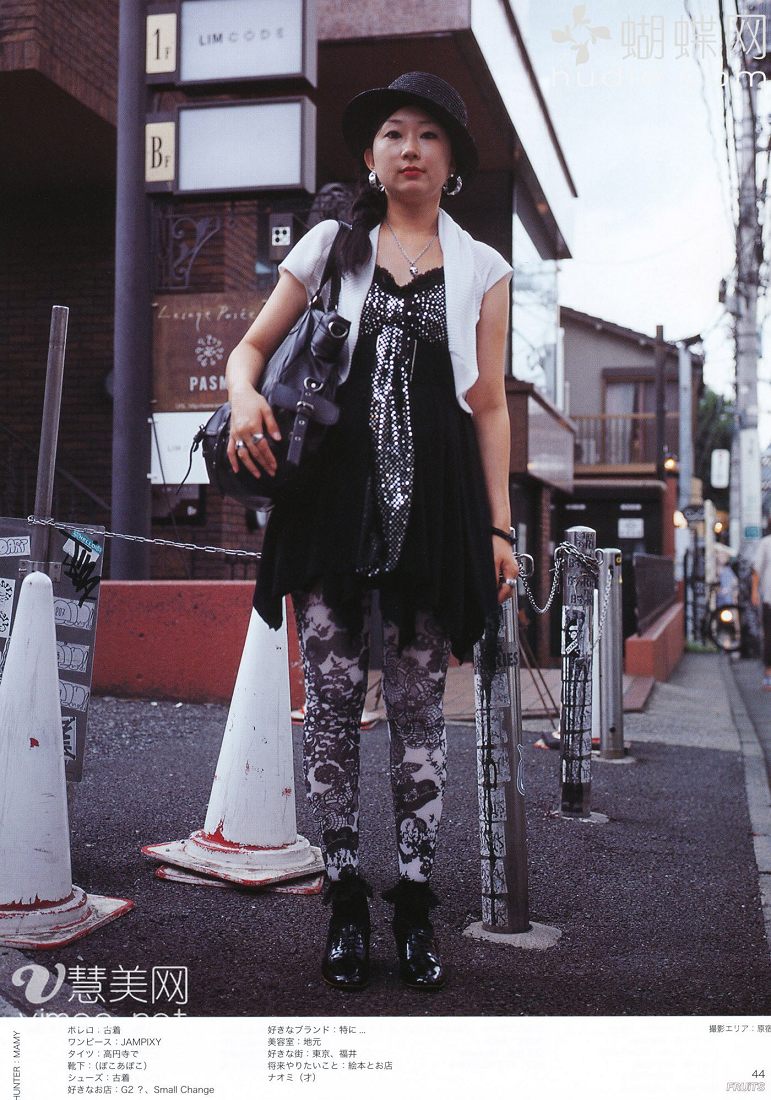 a young woman is posing on a city street in japan. she is wearing a black dress with a sequined bodice, black and white floral leggings, and black boots. she is also wearing a white cardigan, a black hat, and carrying a black purse. the photo is taken from a low angle, making her appear tall and slender. the background is blurred, drawing attention to the woman and her outfit. the overall style of the photo is edgy and fashionable, with a touch of japanese street style.