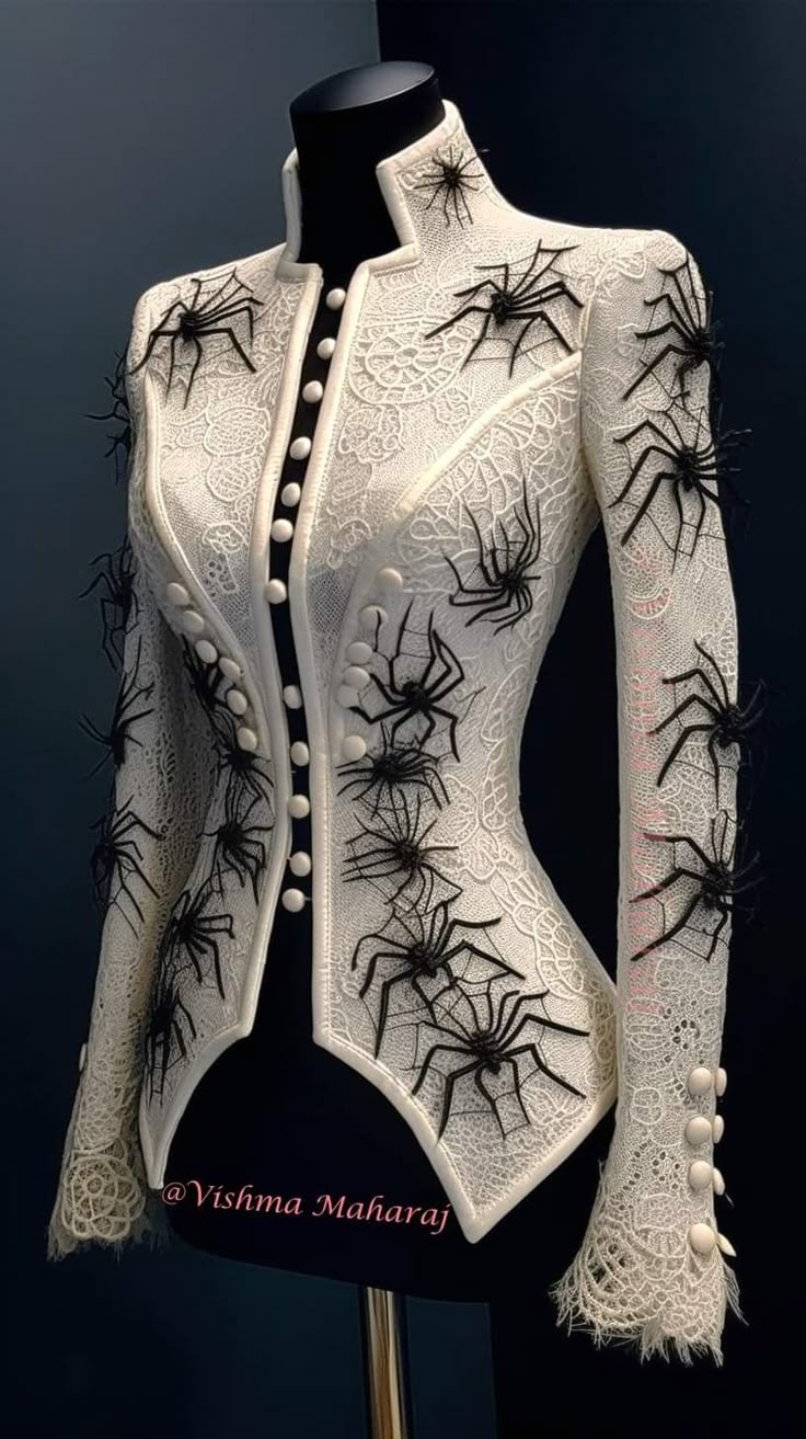 a white lace jacket with black spiders and spiderwebs is displayed on a black mannequin. the jacket has a high collar and buttons down the front. there are spiders and spiderwebs on the shoulders, sleeves, and bodice of the jacket. the jacket has a fitted silhouette and flares out slightly at the bottom.