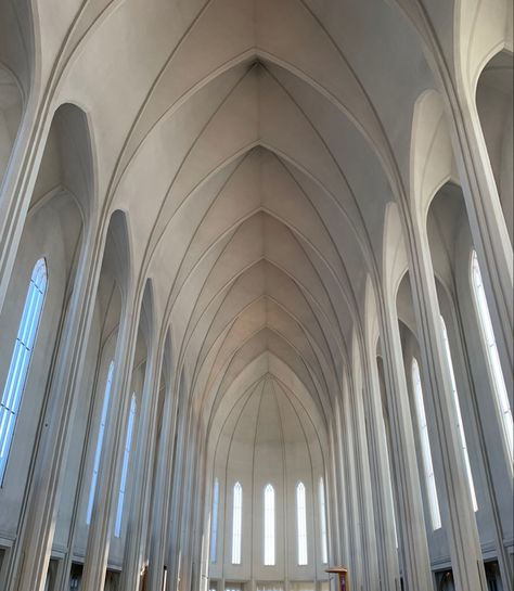 a lowangle view of the interior of hallgrímskirkja church in reykjavík, iceland showcasing the symmetry, ribbed vault, and stained glass windows.