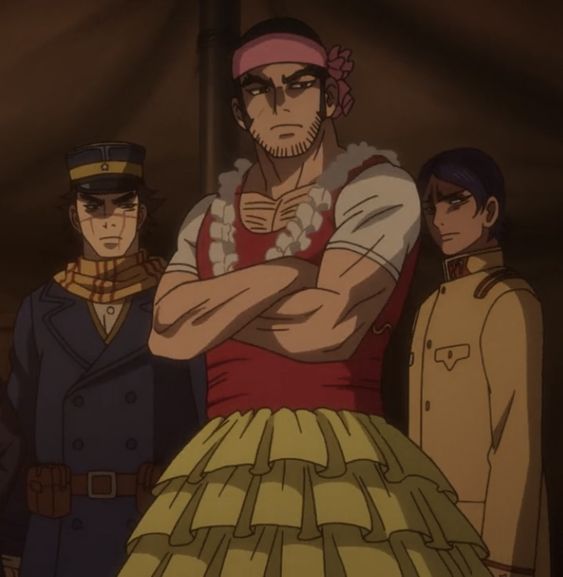the image shows three men standing in a room. the man in the center is the largest of the three and is wearing a red tank top and a yellow skirt. he has a pink headband on and his arms are crossed. the man on the left is wearing a blue military uniform and has a serious expression on his face. the man on the right is wearing a tan military uniform and is looking at the man in the center with a concerned expression. the image is lit from the front and is taken from eye level.