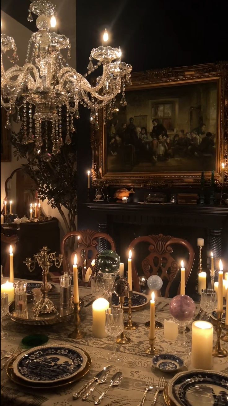 he image shows a beautifully set dinner table in a dimly lit room.  a large crystal chandelier hangs above the table, which is laden with numerous lit candles in ornate candle holders. the table is set with elegant china, silverware, and glassware.  a large antique painting in a gold frame hangs on the wall behind the table, adding to the room's opulent and slightly mysterious atmosphere. the overall aesthetic is dark, romantic, and luxurious, creating a sense of vintage elegance.  the scene is reminiscent of a gothic or historical setting.
