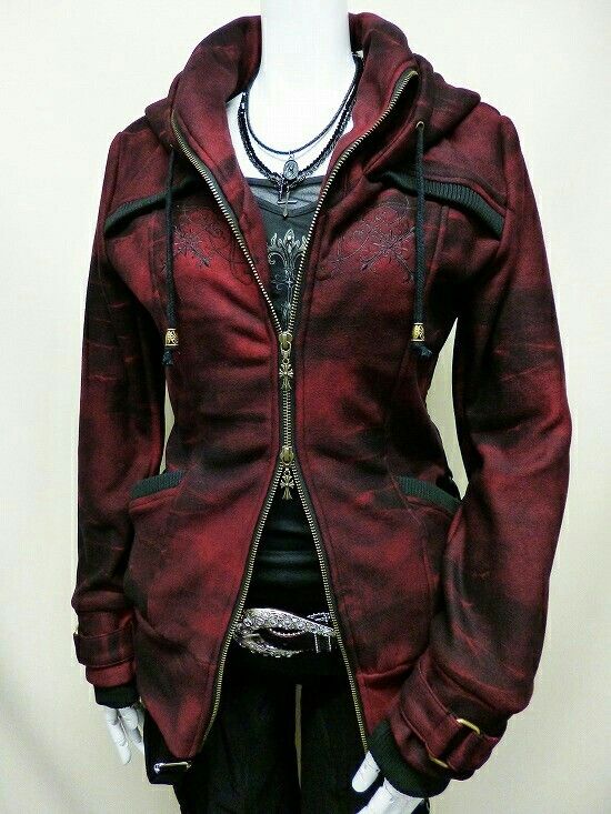a mannequin wears a burgundy gothicstyle hoodie jacket with an open zipper. underneath, a black top and pants are visible, accentuated by a decorative belt. the mannequin also sports layered necklaces with a cross pendant.