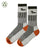 the image shows a pair of grey crew socks with a subtle pattern and orange detailing at the cuffs and heel.  the socks appear to be made of a wool or woolblend material. they are folded slightly, showing both the top and the bottom of the socks. the socks are presented on a plain white background.