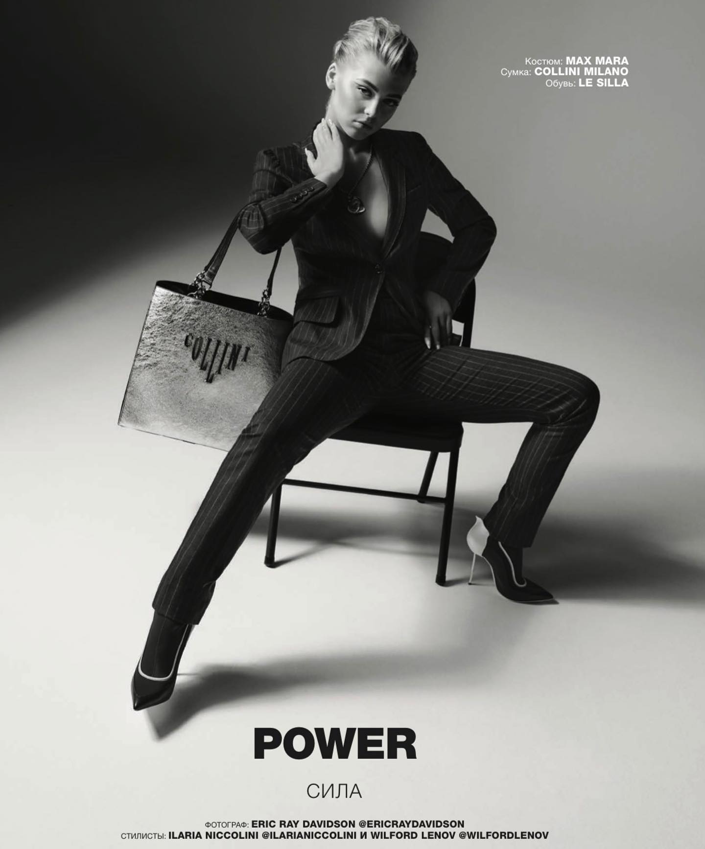 a black and white fashion editorial features a female model seated on a chair, dressed in a pinstripe suit and high heels. she is holding a handbag with the name "collini" displayed on it. the words "power" and its russian translation "сила" are printed at the bottom of the image. information about the clothing brands (max mara, collini milano, le silla) and photographer/stylists are also visible.