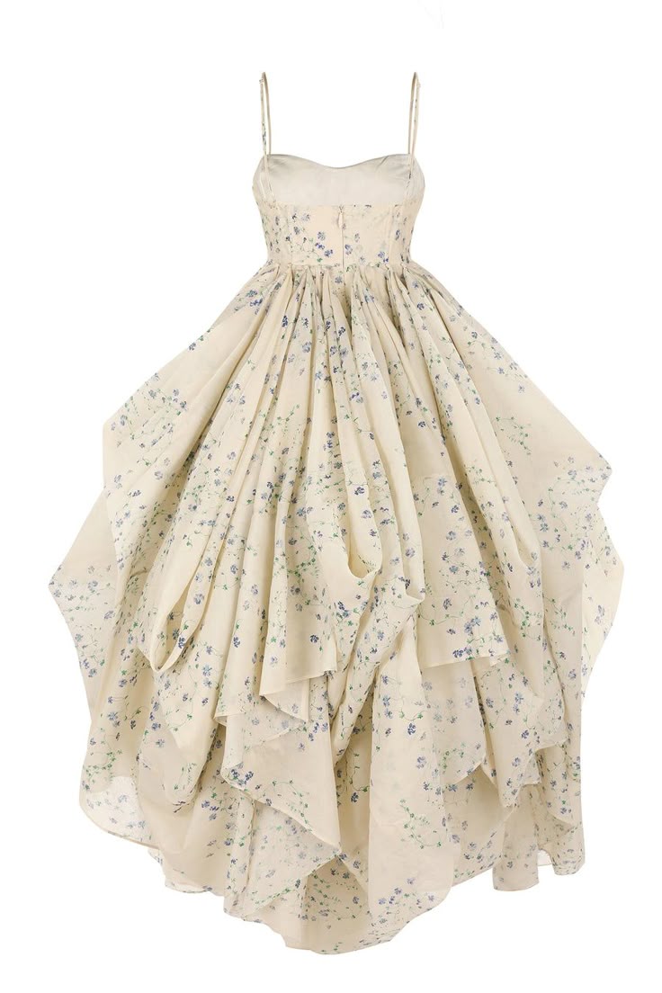 a sleeveless, creamcolored chiffon dress with a blue floral pattern, spaghetti straps, a highlow hem, and ruffled detailing.