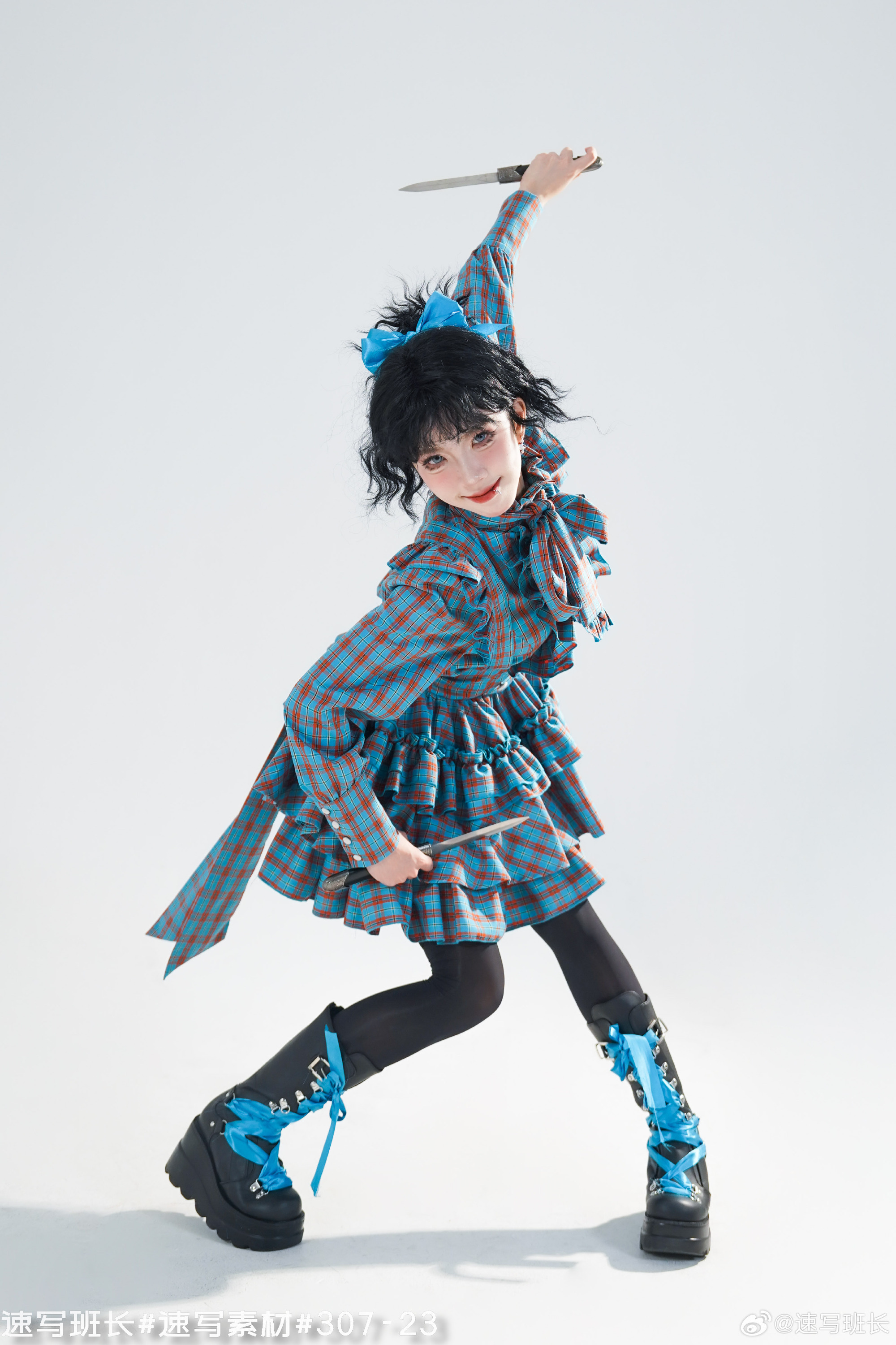 a woman in a blue and brown checkered lolita dress and black platform boots holds two knives in a fighting pose against a white background.