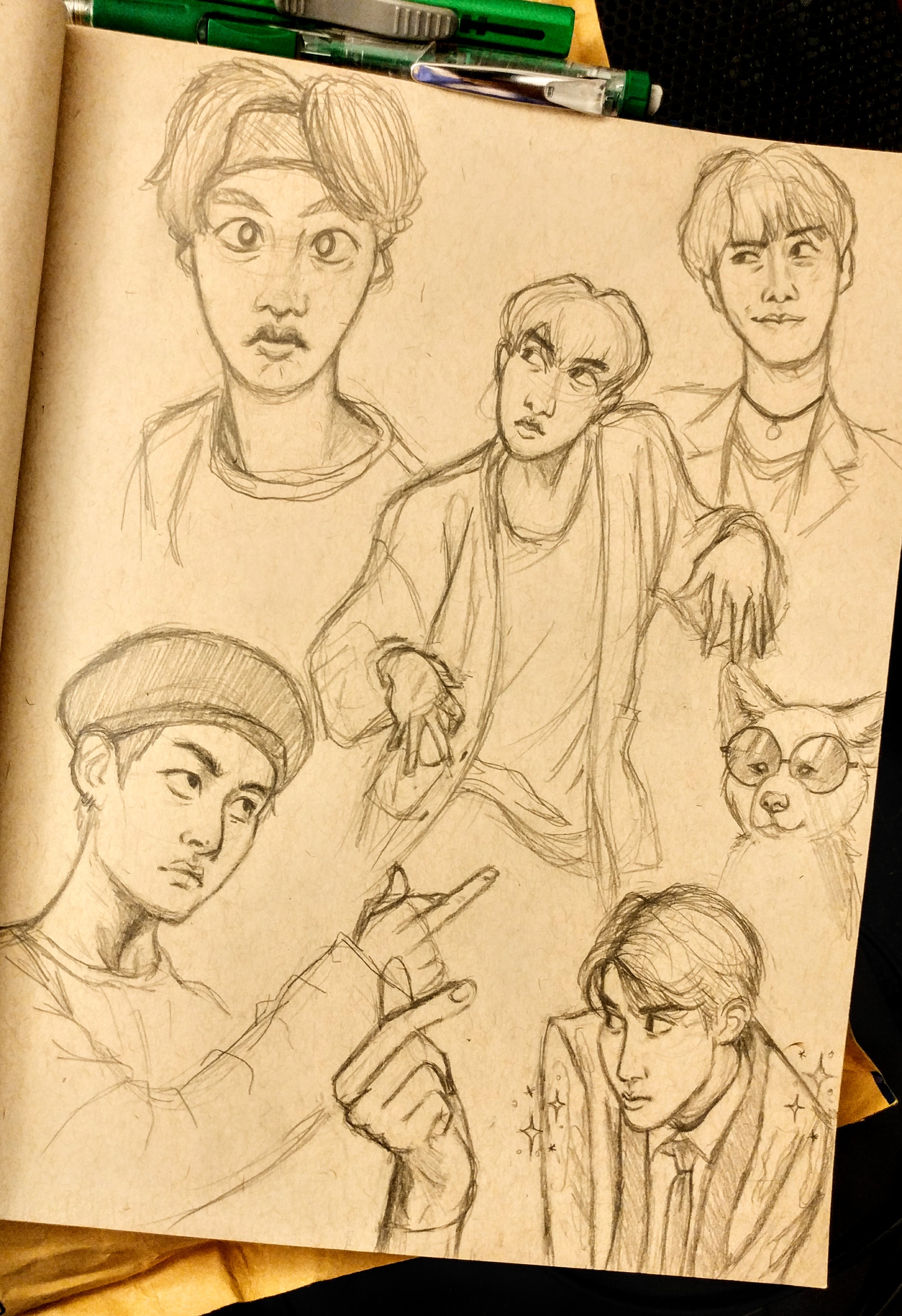 a page from a sketchbook with multiple sketches of park jimin from the kpop group bts. the sketches depict him in different poses and expressions.  the top left sketch is of his face with an exaggerated surprised expression. below that is a small sketch of a dog wearing sunglasses. to the right is a sketch of jimin from the chest up and is glancing to the side.  the largest sketch takes up the center and shows jimin's torso and arms as if he is dancing. in the bottom left corner is a sketch of jimin from the chest up, looking to the side and pointing. the final sketch is of jimin's head and shoulders wearing a suit.
