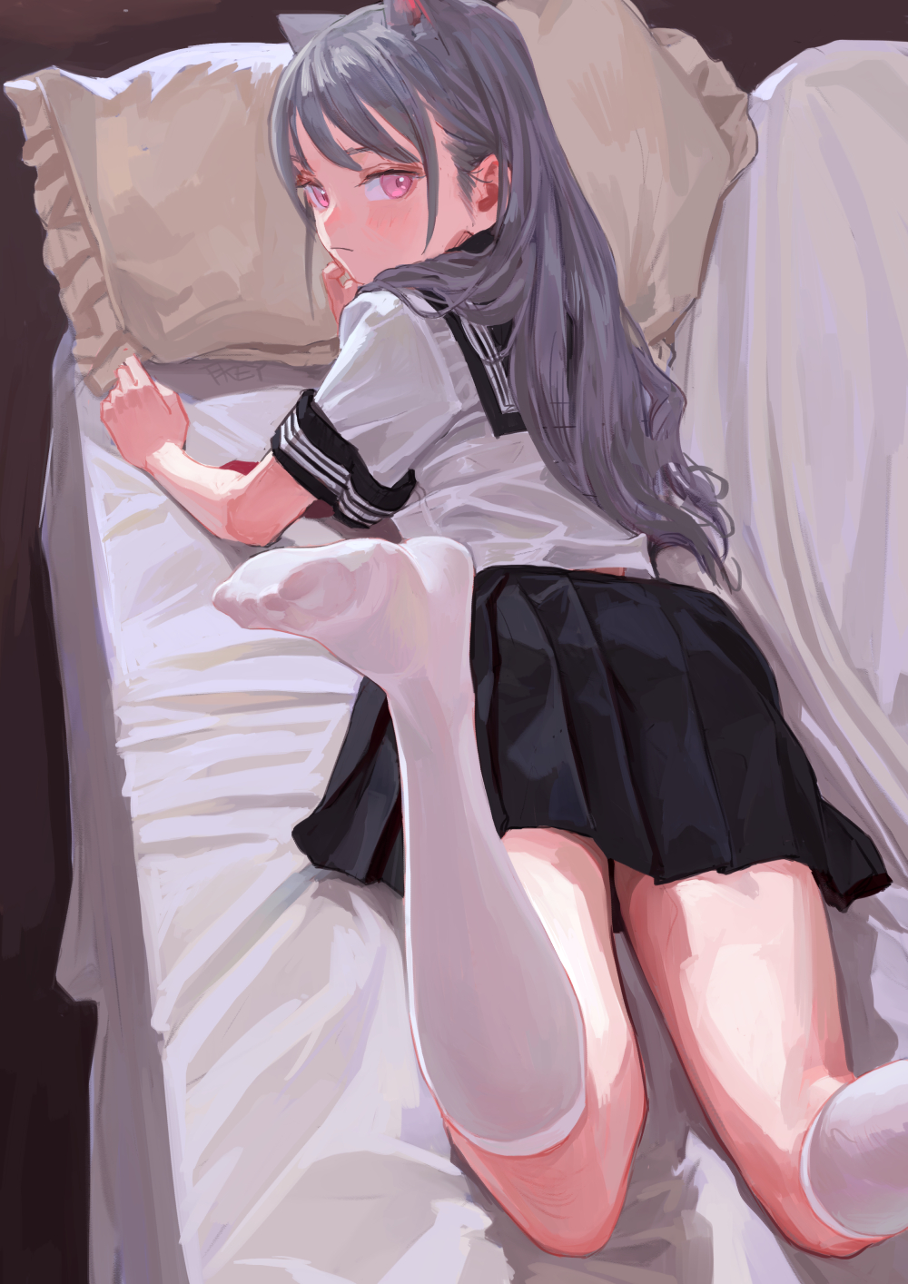 an anime girl with gray hair and pink eyes, wearing a school uniform with a black skirt and white socks, is lying on a bed with cat ears on her head, looking back over her shoulder.