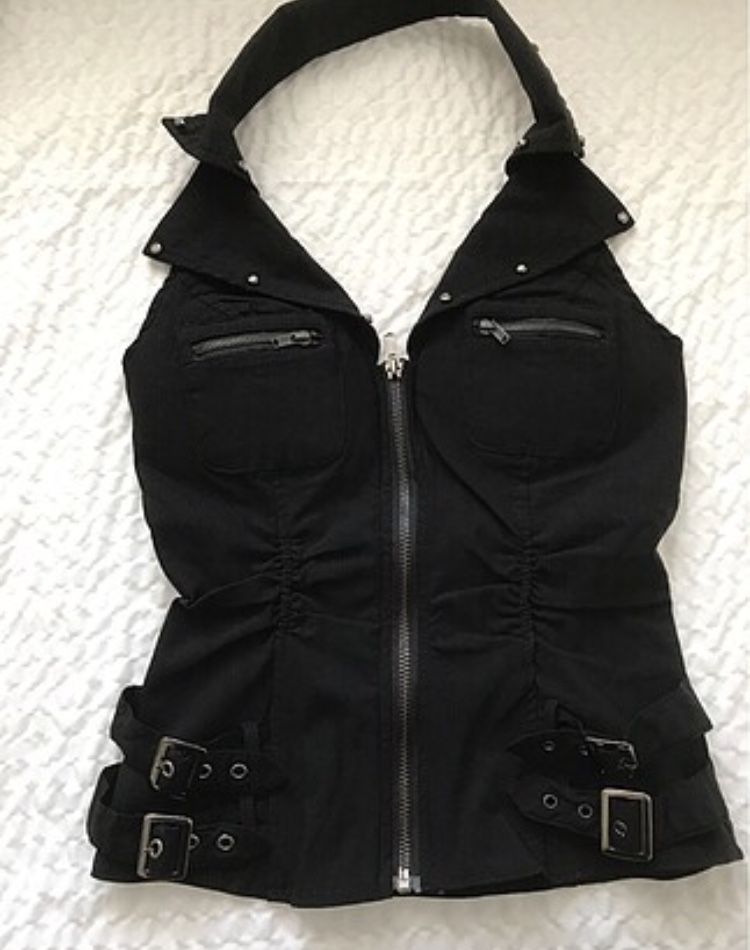this is a black halter top with a zipper closure down the front. it has straps and buckles all around the top and the bottom. the top is made of a stretchy, almost leatherlike material and would be considered goth or punk fashion.
