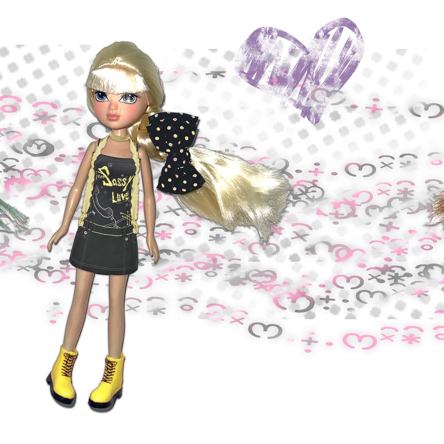 the image features a blondehaired fashion doll, possibly from the 2000s, dressed in a black mini skirt, a black graphic tee with the words "sassy live," and yellow boots. she has a black polkadot bow in her long blonde hair.  the doll is posed against a white background with a scattered pattern of hearts and other doodles in pink and gray.  a purple heart shape is prominent in the upper section of the background. the overall aesthetic is playful and nostalgic.  small portions of other dolls or hair are visible at the edges of the frame.